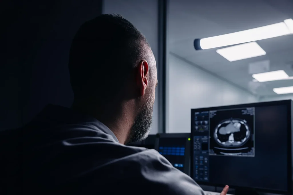 Radiologist reviewing a CT scan at an imaging workstation